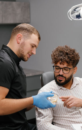 Male Dentist Explaining Implants